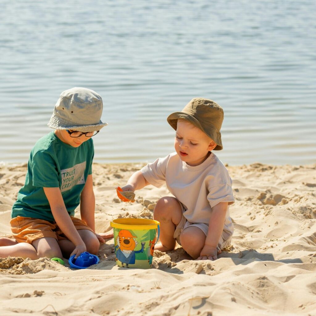 Two children playing in the sand on the beach
