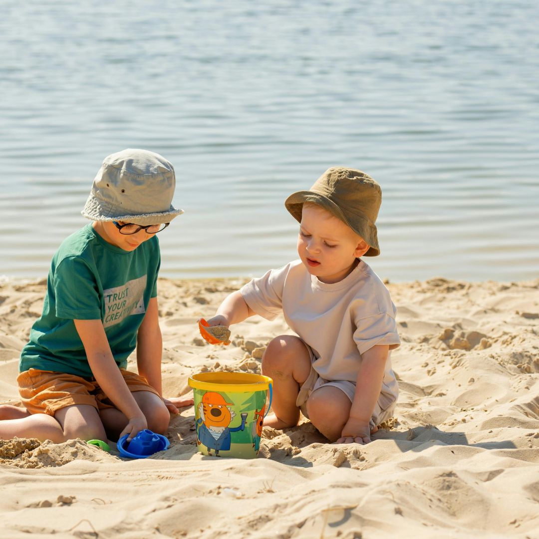 Two children playing in the sand on the beach