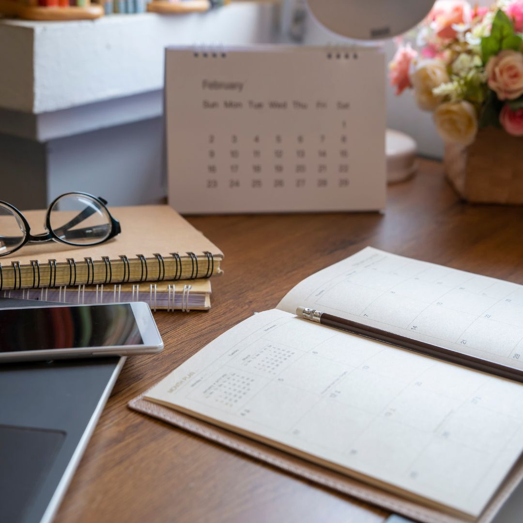 Spring financial planning with a calendar, planner, phone and glasses on a desk